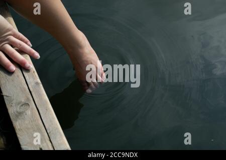 Woman's toes dipping in water Stock Photo