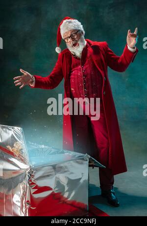 Magic glowing. Modern stylish Santa Claus in red fashionable suit