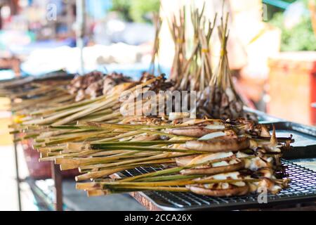 Grilled squids in barbeque way in an Asian market during the summer day. Always this food was fresh and south of Asia is full of market in the streets Stock Photo