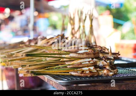 Grilled squids in barbeque way in an Asian market during the summer day. Always this food was fresh and south of Asia is full of market in the streets Stock Photo