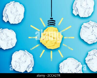 illuminated light bulb in midst of crumpled paper balls, having an idea concept Stock Photo