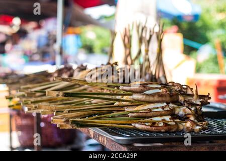 Grilled squids in barbeque way in an Asian market during the summer day. Always this food was fresh and south of Asia is full of market in the streets Stock Photo