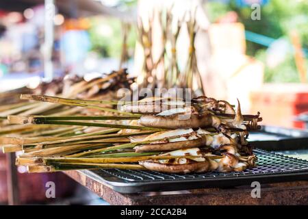 Grilled squids in barbeque way in an Asian market during the summer day. Always this food was fresh and south of Asia is full of market in the streets Stock Photo