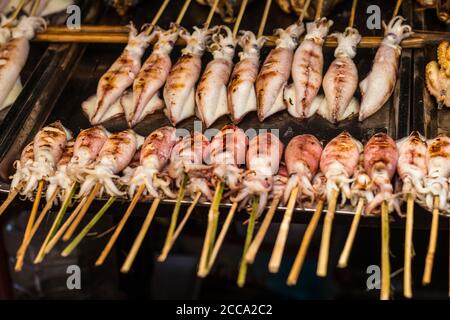 Grilled squids in barbeque way in an Asian market during the summer day. Always this food was fresh and south of Asia is full of market in the streets Stock Photo