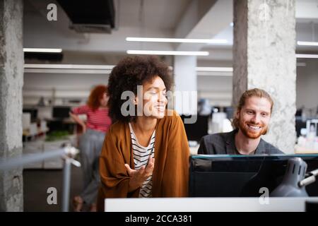 Programmers cooperating at IT company developing apps Stock Photo
