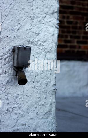 Metal ventilation end of a boiler system, on an urban apartment rooftop, with an exterior brick wall in the background Stock Photo