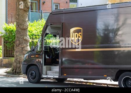 the side of a UPS delivery van parked on a street while delivering Stock Photo