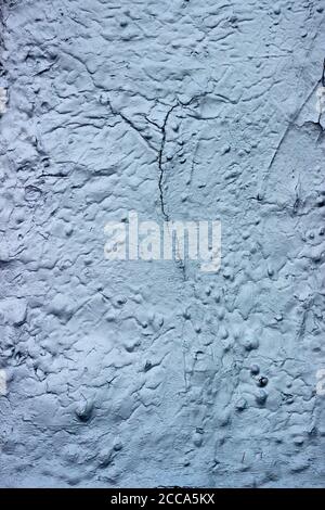 Aging, peeling, cracking, heat-reflective paint on an exterior wall Stock Photo