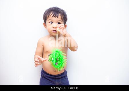 Adorable baby boy playing with Corona virus quarantine or covid-19 toy on white background Stock Photo