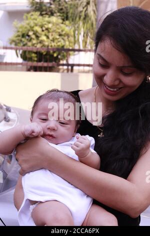 beautiful Indian woman carrying her little boy outdoors Stock Photo