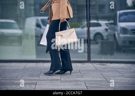 Young female in trendy pants strolling outdoors Stock Photo