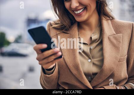 Contented woman staring at her smartphone screen Stock Photo