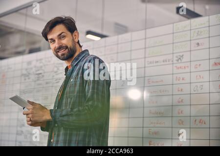 Joyful young man using tablet computer in office Stock Photo