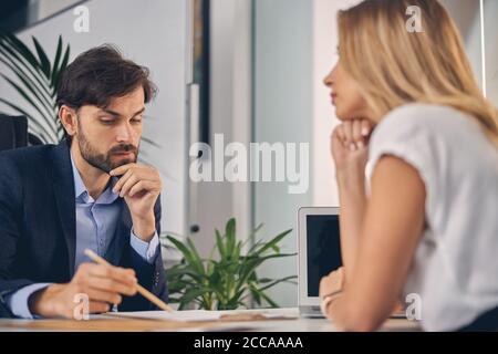 Bearded young man working with female colleague in office Stock Photo