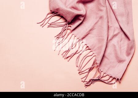 Pink cozy scarf with tassels on pastel background. Minimal winter or autumn background for your design Stock Photo