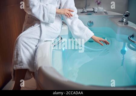 Lady in a bathrobe preparing for a water procedure Stock Photo