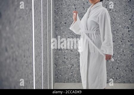 Woman in a bathrobe at the wall Stock Photo