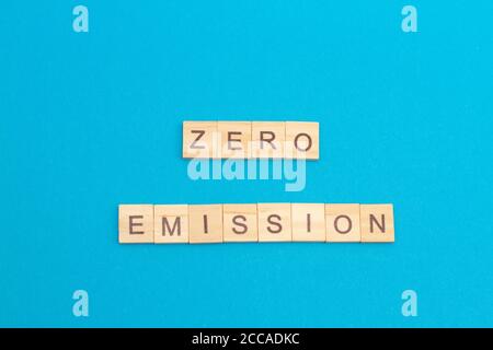 Word ZERO EMISSION made from wooden cubes on blue. Eco-friendly concept. Selective focus Stock Photo