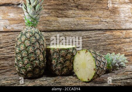Pineapple fruit. Pineapple in halves. Detox diet. Plant for juices. Tropical fruits. Natural food and detox. Pineapple on wooden background. Tropical Stock Photo