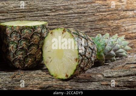 Pineapple fruit. Pineapple in halves. Detox diet. Plant for juices. Tropical fruits. Natural food and detox. Pineapple on wooden background. Tropical Stock Photo
