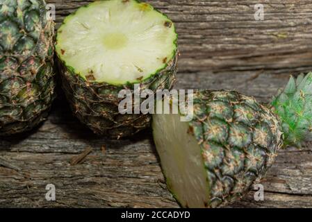 Pineapple fruit. Pineapple in halves. Detox diet. Plant for juices. Tropical fruits. Natural food and detox. Pineapple on wooden background. Tropical Stock Photo