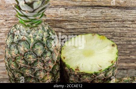 Pineapple fruit. Pineapple in halves. Detox diet. Plant for juices. Tropical fruits. Natural food and detox. Pineapple on wooden background. Tropical Stock Photo