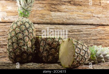 Pineapple fruit. Pineapple in halves. Detox diet. Plant for juices. Tropical fruits. Natural food and detox. Pineapple on wooden background. Tropical Stock Photo