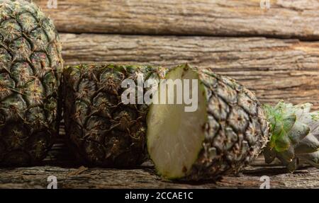 Pineapple fruit. Pineapple in halves. Detox diet. Plant for juices. Tropical fruits. Natural food and detox. Pineapple on wooden background. Tropical Stock Photo