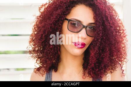Beautiful Afro American woman with curly red hair posing for the camera Stock Photo