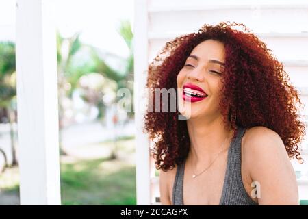 Beautiful Afro American woman with curly red hair laughing Stock Photo