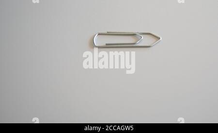 Paper clip on white background. Office supplies and stationery. Clip for use on sheets of paper. Bookstore and stationery utensils. Stock Photo