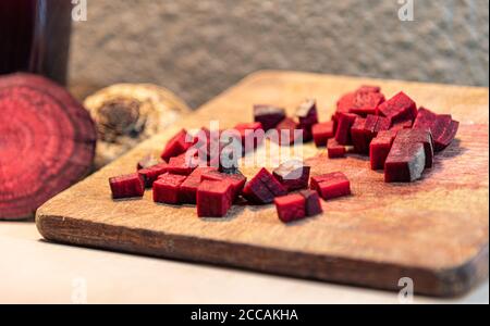 Beet (Beta vulgaris L.) chopped on a wooden board next to broken tubers. Vegetable for salads. Vegetable used in Brazilian cuisine. Source of sugar pr Stock Photo