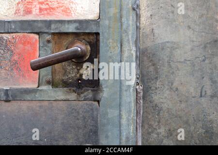 Close up of a old rusty door handle on a glass door in a abandoned greenhouse Stock Photo