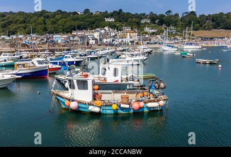Fishing boat and small pleasure boats moored at the Cobb, Lyme Regis, a popular seaside holiday resort on the Jurassic Coast in Dorset, SW England Stock Photo