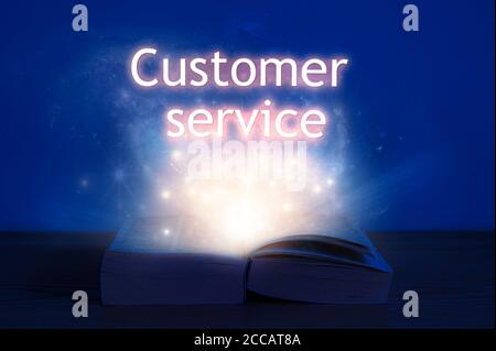 Open book with customer service inscription. Light coming from open book with words customer service Stock Photo