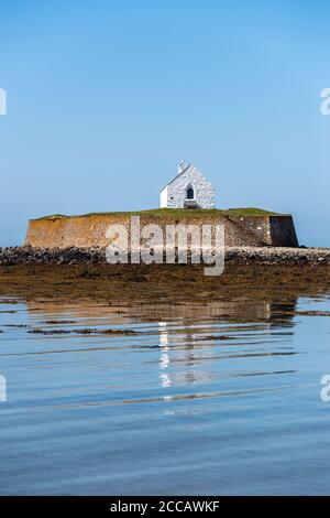 St Cwyfan's medieval church, Llangadwaladr, Anglesey, North Wales. Located on the small tidal island of Cribinau, it's known as the Church in the Sea. Stock Photo