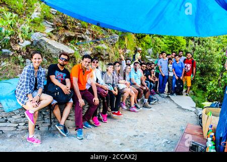 Travellers in the green mountains enjoying the natural beauty of our earth. Top of Triund Peak. Trekking in the Himalaya mountains. Landscape - Image Stock Photo