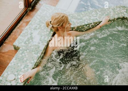 Pretty young woman relaxing in the whirlpool bathtub Stock Photo