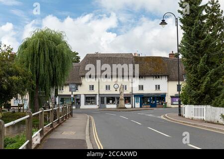 King Alfred’s statue in Market Place and Phoenix Row thatched buildings with the River Avon to one side. Pewsey, Wiltshire, England, UK Stock Photo