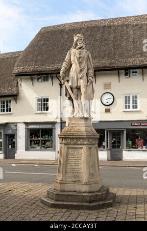 Stone statue of King Alfred in the Market Place of Pewsey with Phoenix Row thatched grade 11 listed buildings in the background, Pewsey, England, UK Stock Photo