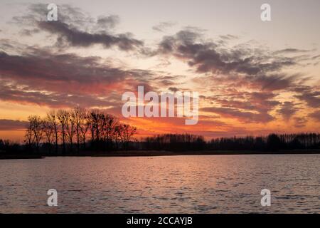 Colourful clouds after sunset at the lake Stock Photo