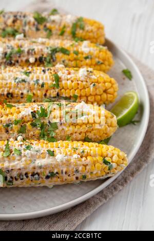 Homemade Elote Mexican Street Corn on a plate, side view. Stock Photo