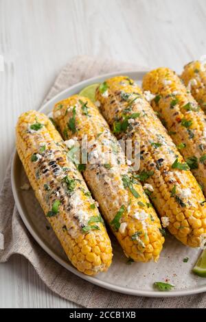 Homemade Elote Mexican Street Corn on a plate, side view. Stock Photo