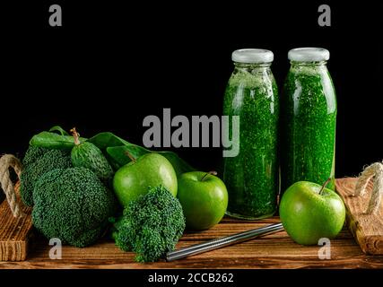 Bottles of green smoothie with ingredients on black background. Alkaline diet concept. Copy space Stock Photo