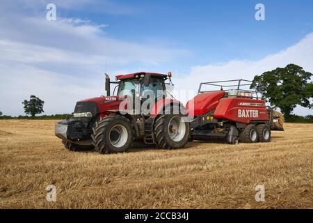 Case Puma 2 Tractor Baling In A Lincolnshire Field With A Large Massey Ferguson 2270xd Baler On An August Summer Evening Stock Photo Alamy