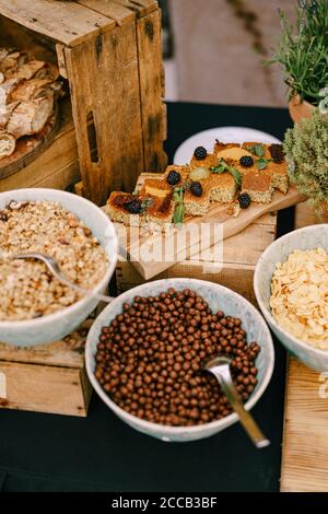 Plates with breakfast cereal and blackberry pie on a wooden stand. Stock Photo