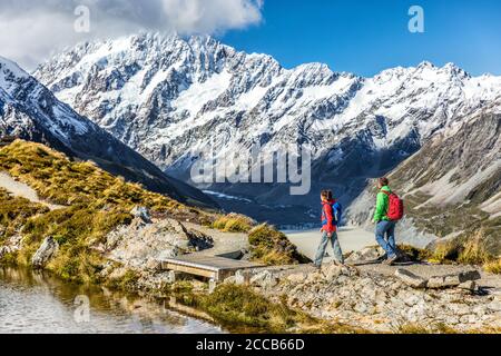 Hiking travel nature hikers in New Zealand mountains. Couple people walking on Sealy Tarns hike trail route with Mount Cook landscape, famous tourist Stock Photo