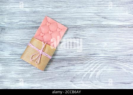 Pink chocolate whole bar decorated with slices of fruit nuts and slices against gray background. Trendy handmade chocolate. Gift Idea. Selective focus Stock Photo