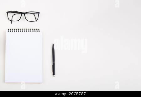 White notepad with black pen and glasses on light table,  Stock Photo