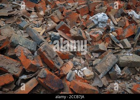 Heap of broken old red brick close-up. Red brick texture folded and laid out in one plane. Stock Photo